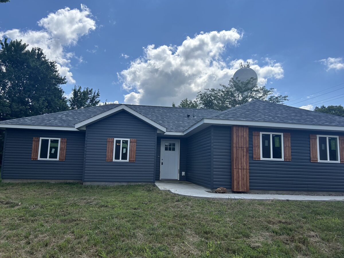 Completed home with navy lap siding and a new shingle roof by Zerkle Construction